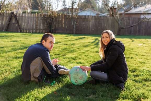 2 people sitting on grass